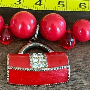 Red beaded necklace with jeweled handbag charm. Vintage.